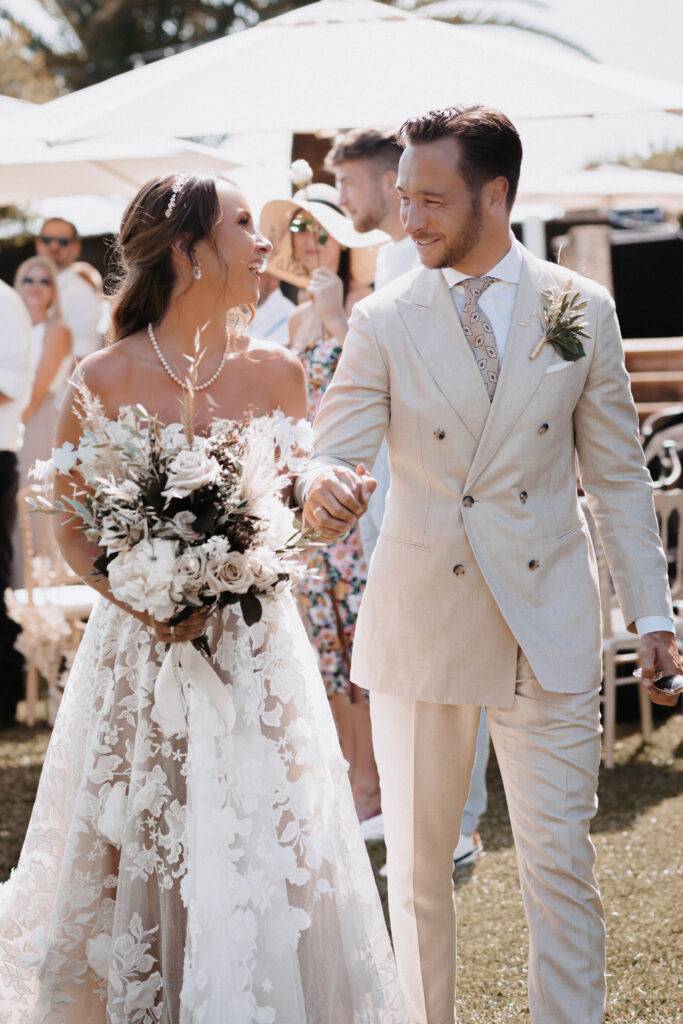 Das Brautpaar nach der freien Trauung beim Auszug. Hand in Hand gehen Sie durch den Gang ihrere Gäste und schauen sich dabei an. Hochzeitsfotograf-Hamburg