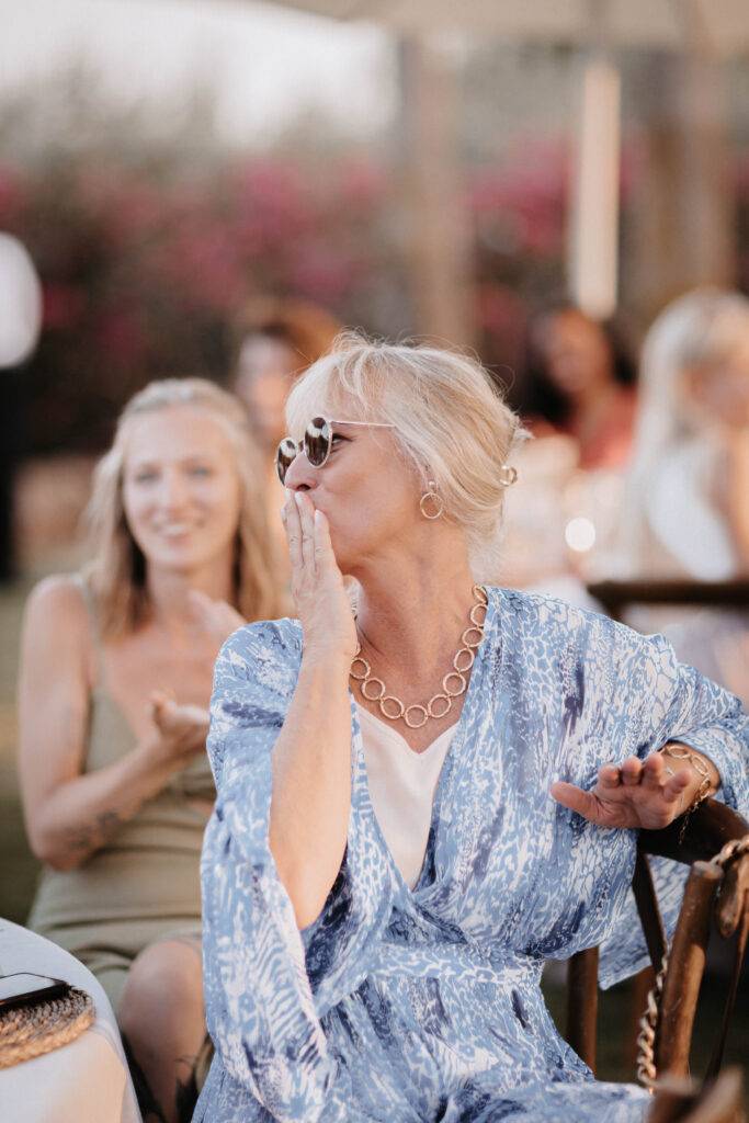 Foto von der Brautmutter. Sie hat eine Sonennbrille auf und ein blaues Kleid an. Schaut dabei nach links zu ihrer Tochter. Hochzeitsfotograf-Hamburg