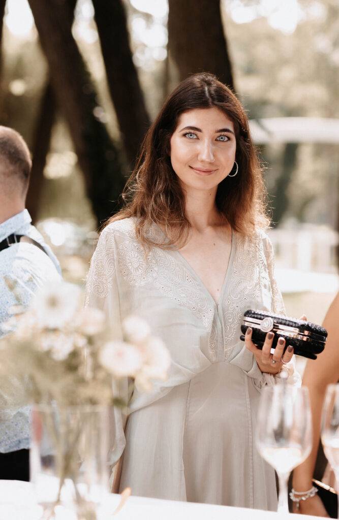 Portrait von einem Gast auf einer Hochzeit. Sie schaut in die Kamera mit braunen Haaren und einem hellen Kleid. Hochzeitsfotograf-Hamburg
