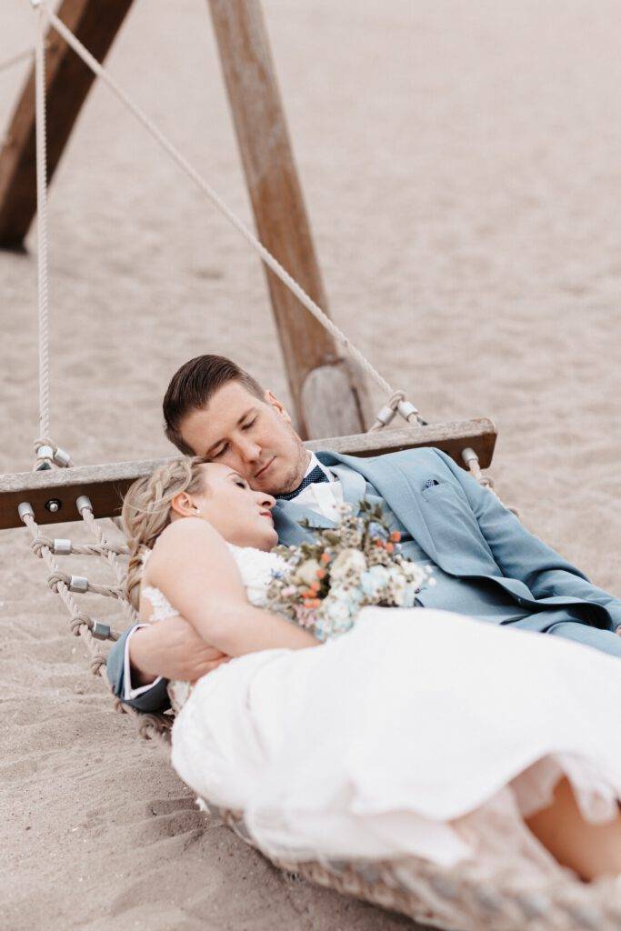 Das Brautpaar liegt engumschlungen in einer Hängematte und haben die Augen dabei geschlossen