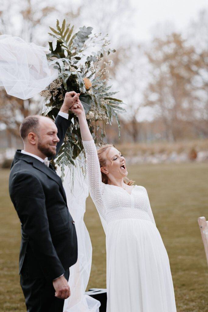 Das Brautpaar hand in hand in die höhe gerissen nachdem die freie trauung vorbei ist. Hochzeitsfotograf-Hamburg