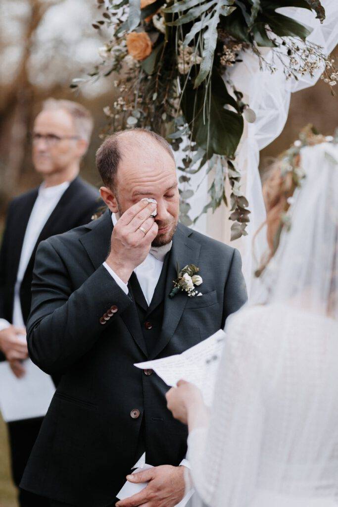 Der Bräutigam wischt sich die Tränen bei der Trauung weg während die Braut. Hochzeitsfotograf-Hamburg