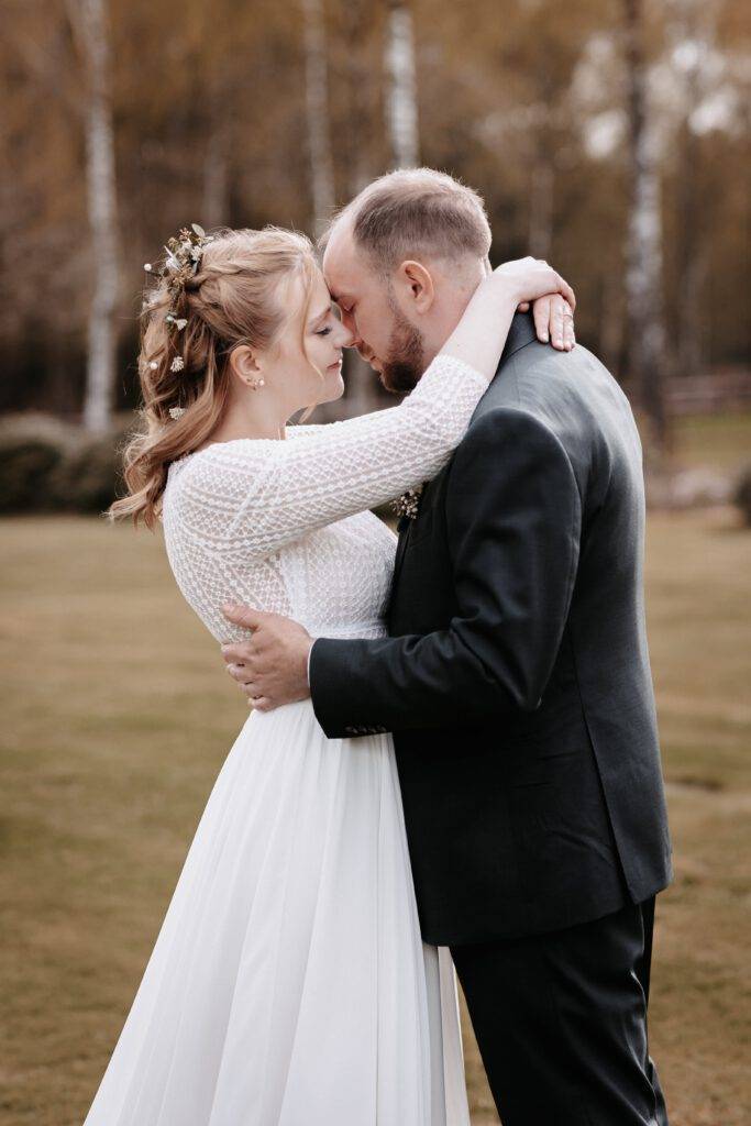 Das Brautpaar steht Stirn an Stirn voreinander und umarmen sich dabei. Hochzeitsfotograf-Hamburg