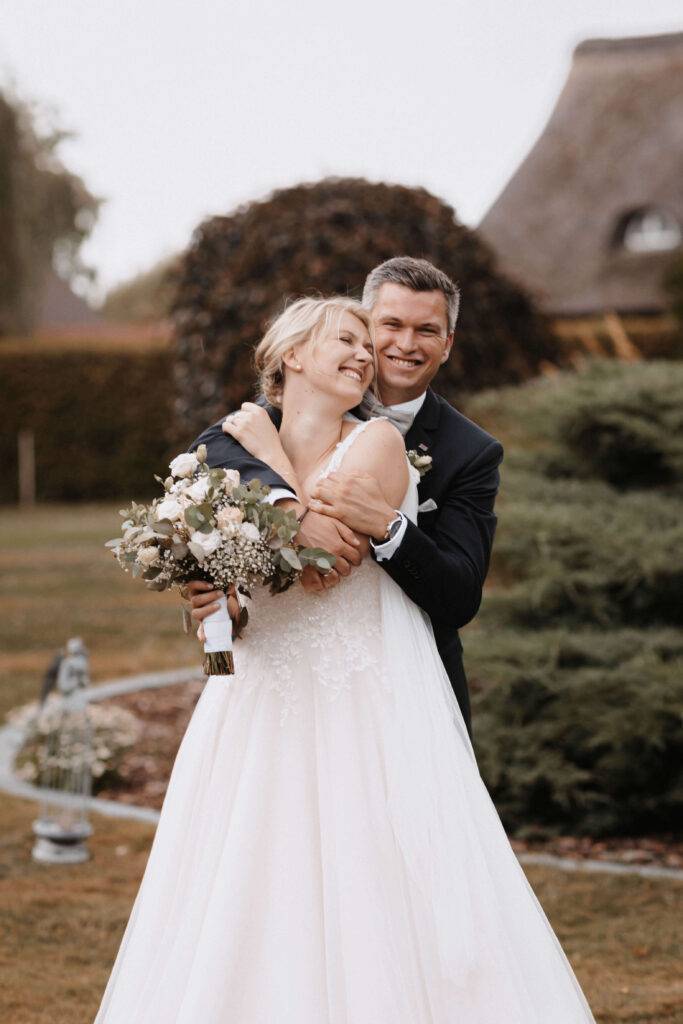 Das Brautpaar umarmt sich und schaut sich dabei an