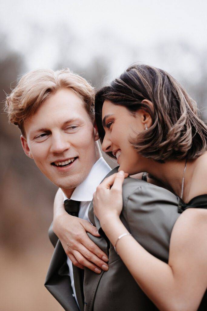 Die Braut ist auf dem Rücken des Bräutigams und beide lachen. Hochzeitsfotograf Hamburg. Hochzeitsfilm Hamburg