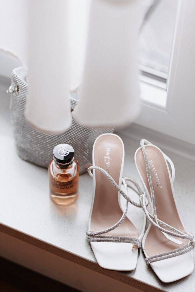 Detailaufnahmen von dem Parfum, Schuhe und Tasche der Braut. Hochzeitsfotograf Hamburg. Hochzeitsfilm Hamburg