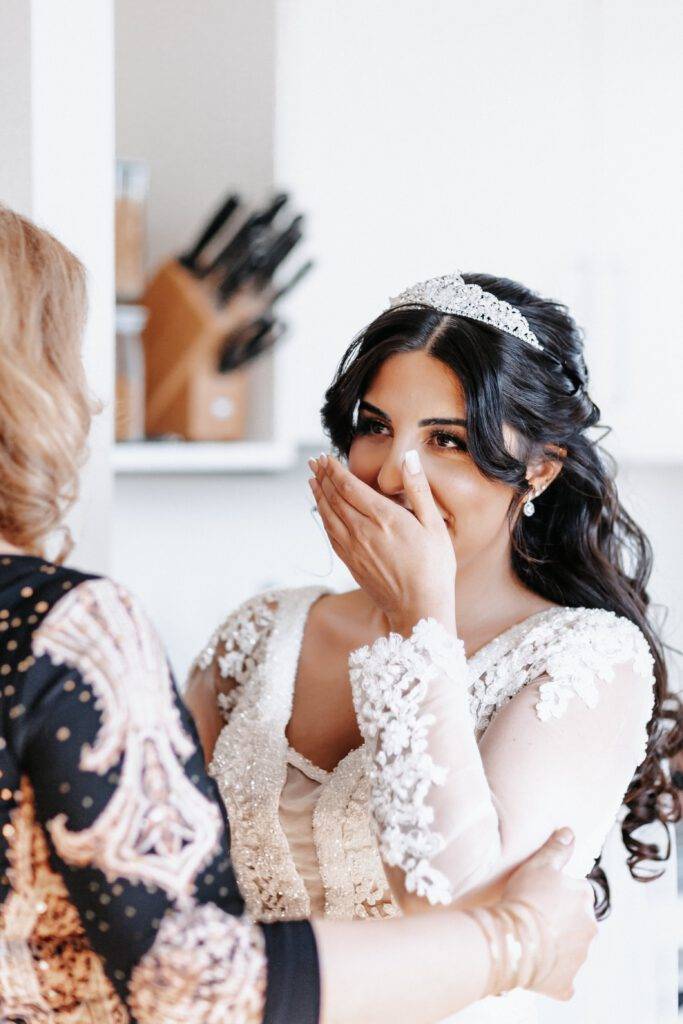 Die Brautmutter sieht zum ersten mal ihre Tochter im Hochzeitskleid. Die Braut hat ihre Hand vor dem Mund und schaut ihre Mutter an. Hochzeitsfotograf Hamburg. Hochzeitsfilm Hamburg