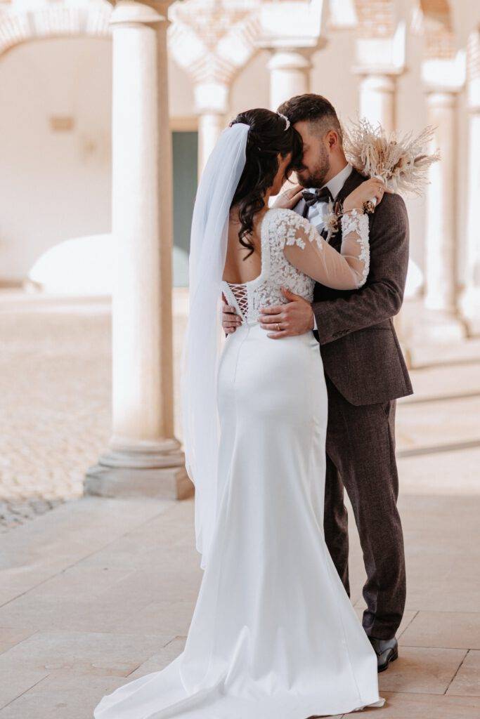 Voreinander mit Stirn an Stirn steht das Brautpaar. Die Braut ist von hinten zu sehen. Hochzeitsfotograf Hamburg. Hochzeitsfilm Hamburg