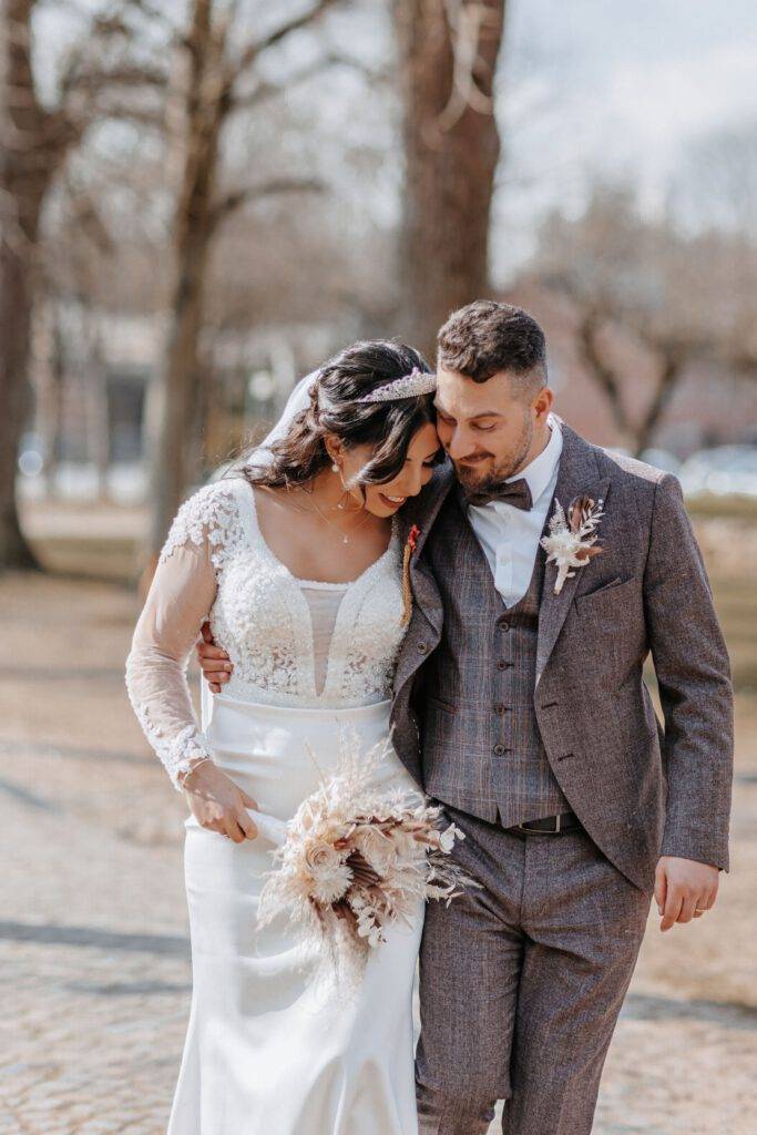 nebeneinander geht das Hochzeitspaar einen Weg entlang. Hochzeitsfotograf Hamburg. Hochzeitsfilm Hamburg