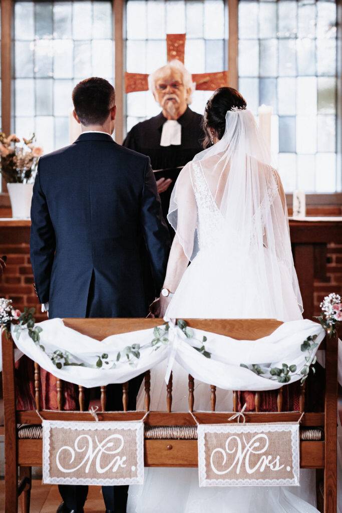 Braut und Bräutigam vor dem Pastor bei der Trauung. Hochzeitsfotograf Hamburg