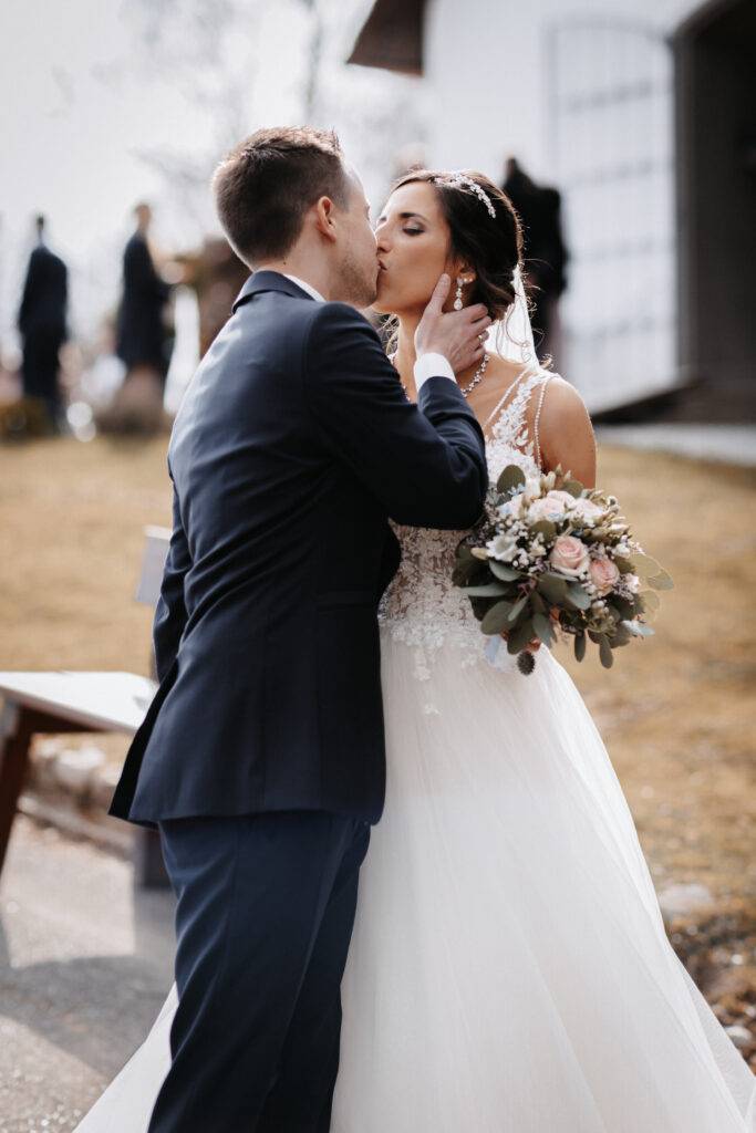 Das Brautpaar küsst sich vor der Kirche nach der Trauung Hochzeitsfotograf Hamburg. Hochzeitsfilm Hamburg