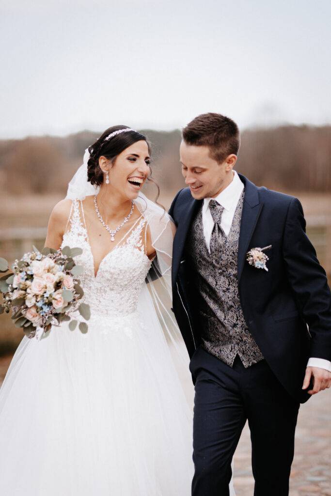 Ineinandergehakt geht das Brautpaar die Straße entlang und strahlt freude aus. Hochzeitsfotograf Hamburg. Hochzeitsfilm Hamburg