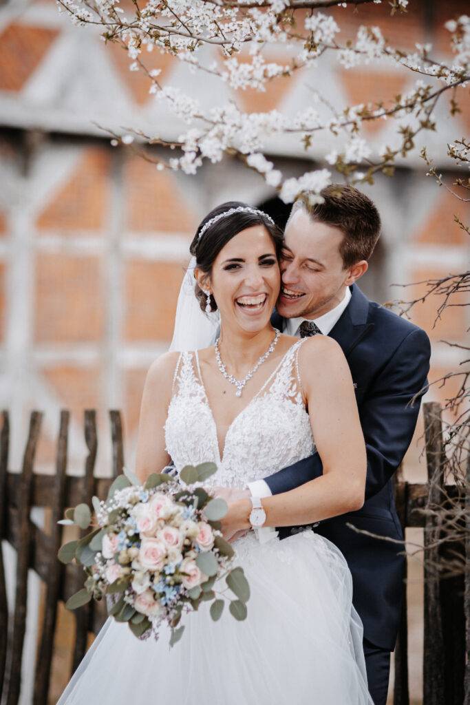 Das Brautpaar lacht gemeinsam und schaut in die Kamera Hochzeitsfotograf Hamburg. Hochzeitsfilm Hamburg