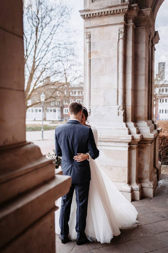 Das Brautpaar schaut sich in die Augen vor dem Rathaus Harburg. Hochzeitsfotograf Hamburg. Hochzeitsfilm Hamburg