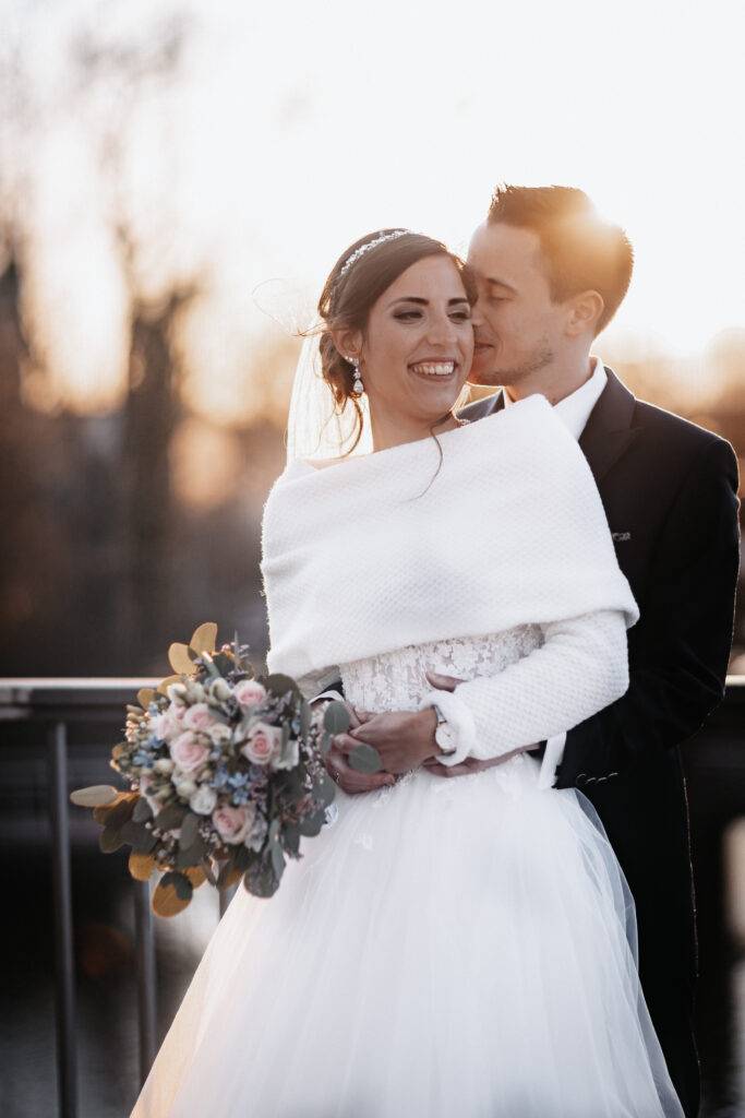 Das Hochzeitspaar umarmt sich bei Sonnenuntergang und lachen. Hochzeitsfotograf Hamburg. Hochzeitsfilm Hamburg