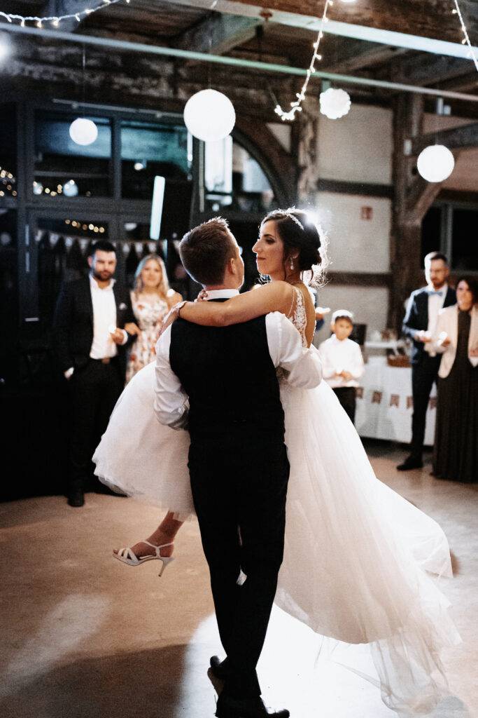 Hochzeitstanz. Die Braut wird vom Bräutigam mit einer Drehung durch die Luft gehoben. Beide schauen sich in die Augen. Hochzeitsfotograf Hamburg. Hochzeitsfilm Hamburg