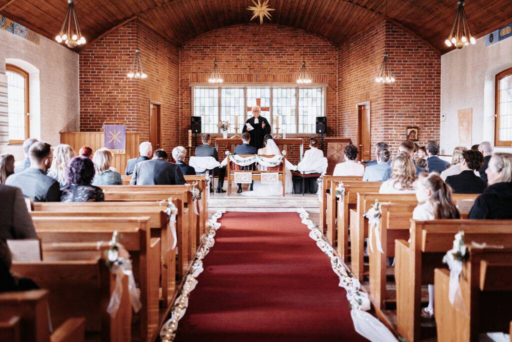 Weg zum Altar bei der Traaung. Braut und Bräutigam sitzen vor dem Pastor. Braut und Bräutigam vor dem Pastor bei der Trauung. Hochzeitsfotograf Hamburg