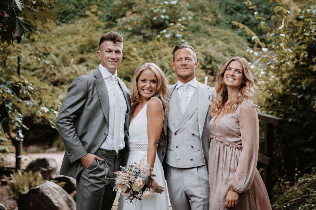 Gruppenfoto von dem Brautpaar und zwei Trauzeugen